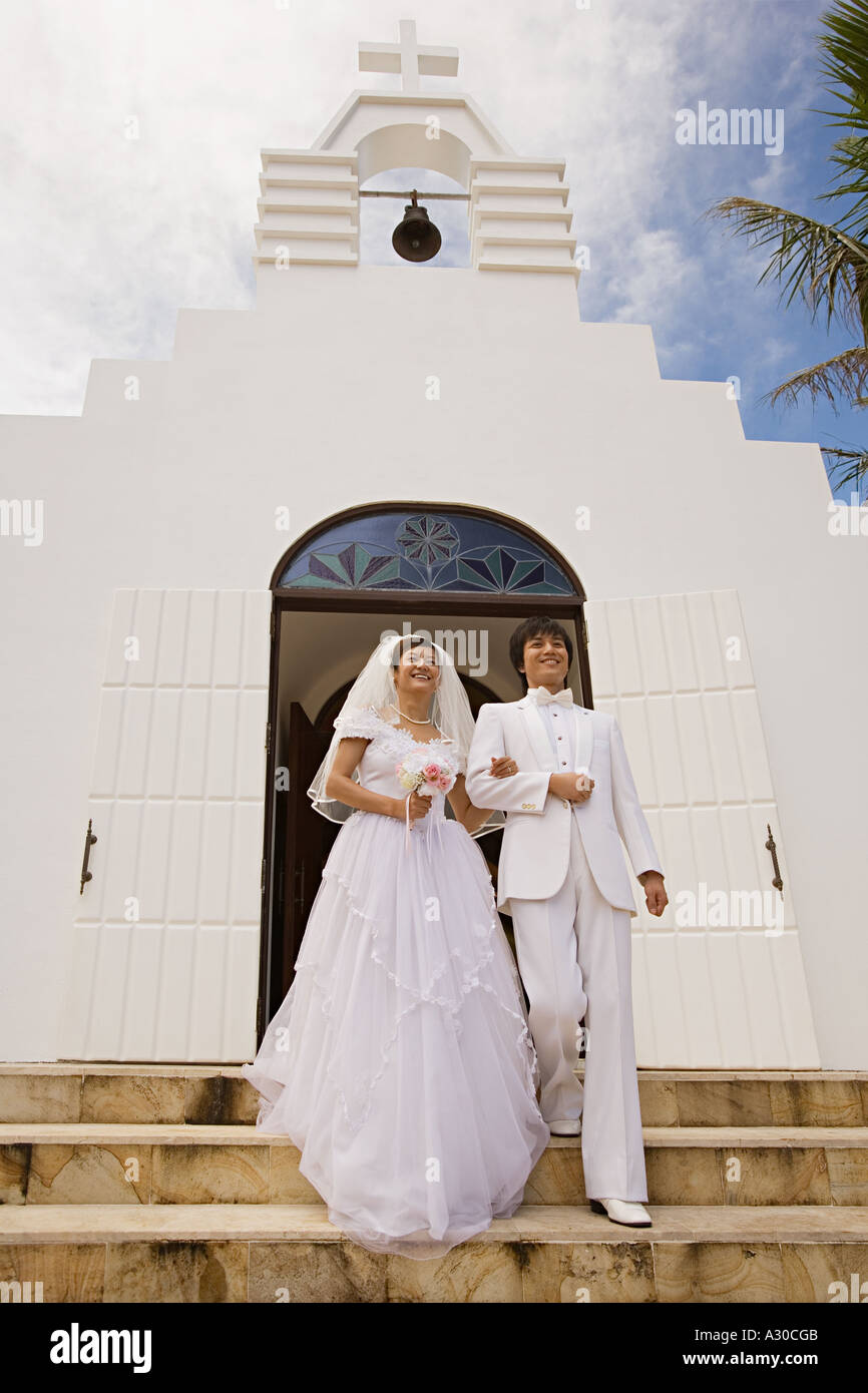 Newlyweds on church steps Stock Photo