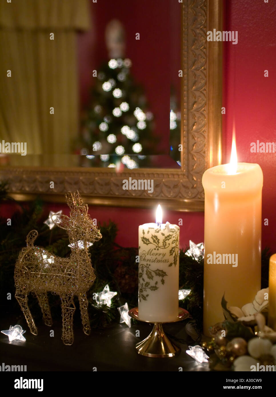 christmas candles and decorations on mantelpiece with christmas tree reflected in gold framed mirror stock - Christmas Candle Decorations christmas candles and decorations on mantelpiece with christmas tree reflected in gold framed mirror stock - Christmas Candle Decorations
