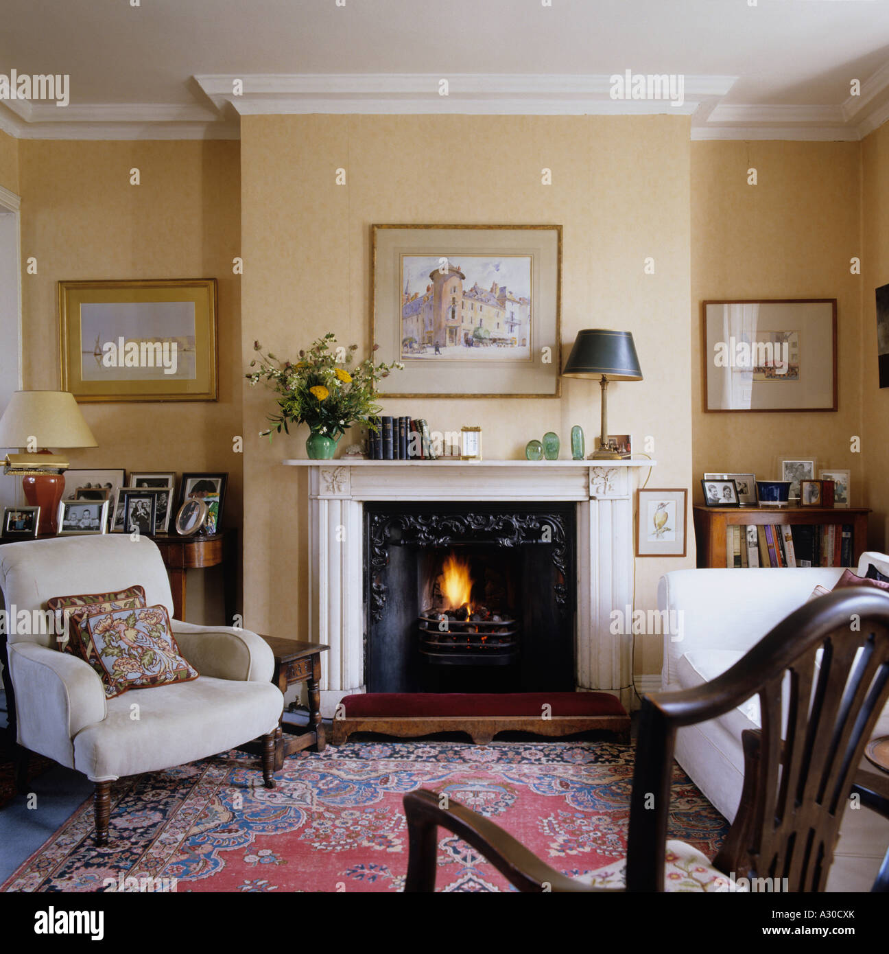 English country style living room with mantel piece, arm chair and rug Stock Photo
