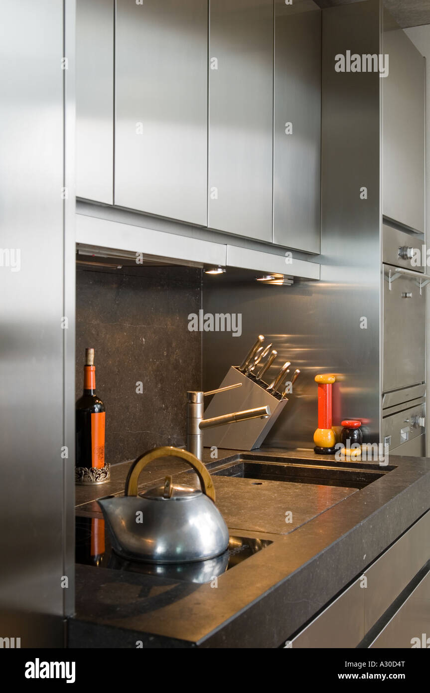 View of Modern stainless steel kitchen with sink, kettle and knife rack in a ...