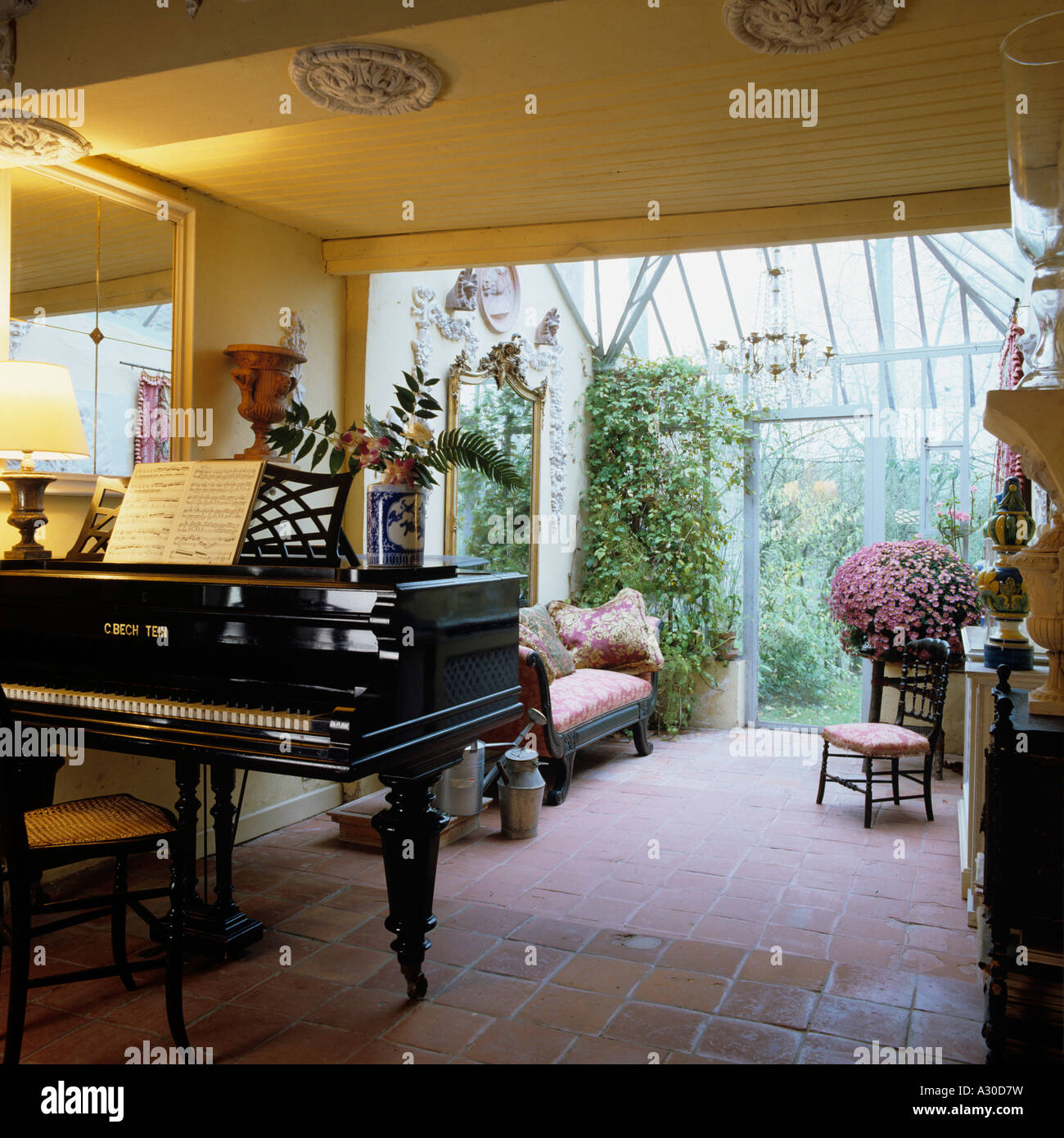 Grand piano in flagstone floored conservatory Stock Photo
