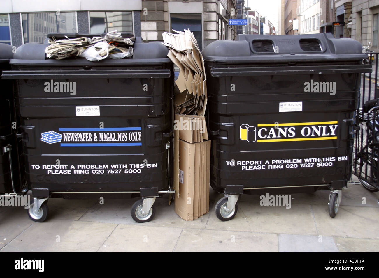 Two recycling bins for newspaper magazines and aluminium cans London UK