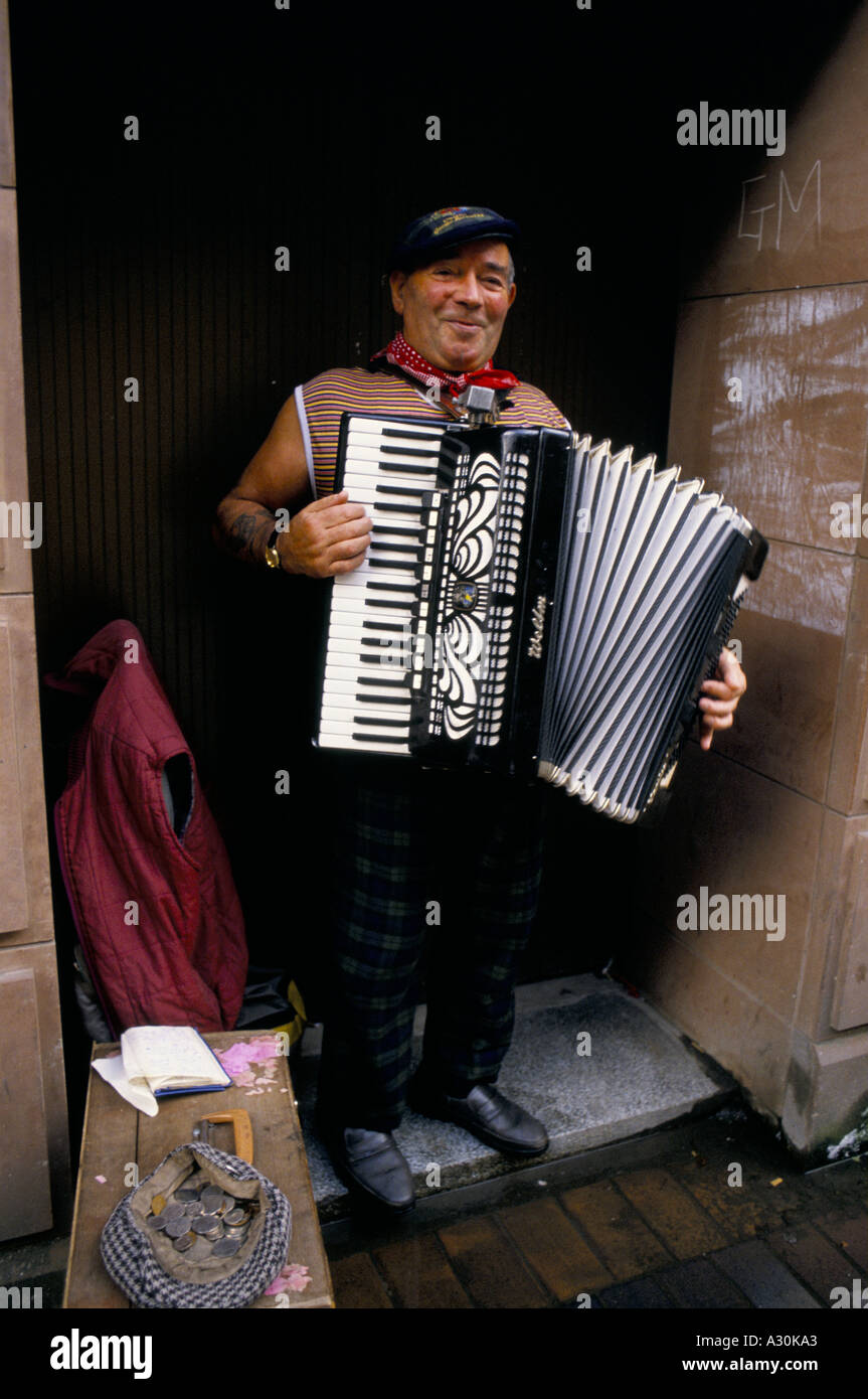 busker with cap full of coins playing accordion on street glasgow