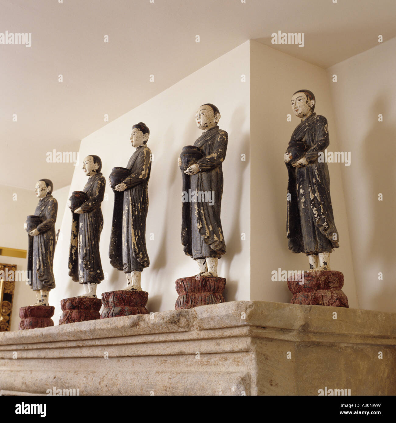 Row of Chinese figurines on a stone mantelpiece Stock Photo