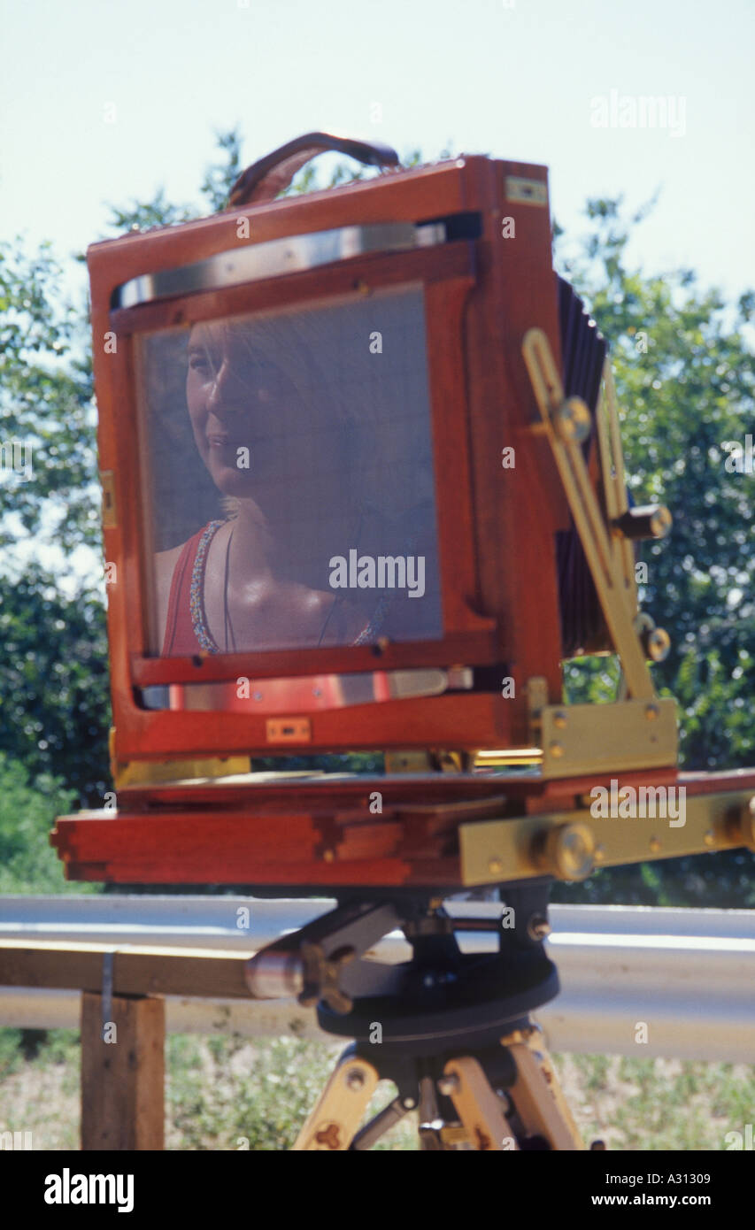 Female photographer reflection seen on the ground glass of a wooden