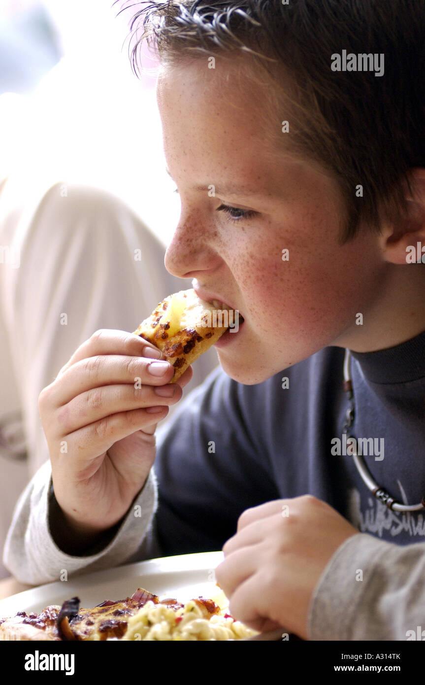 Royalty free photograph of British student teenager eating pizza in London fast food restaurant UK Stock Photo