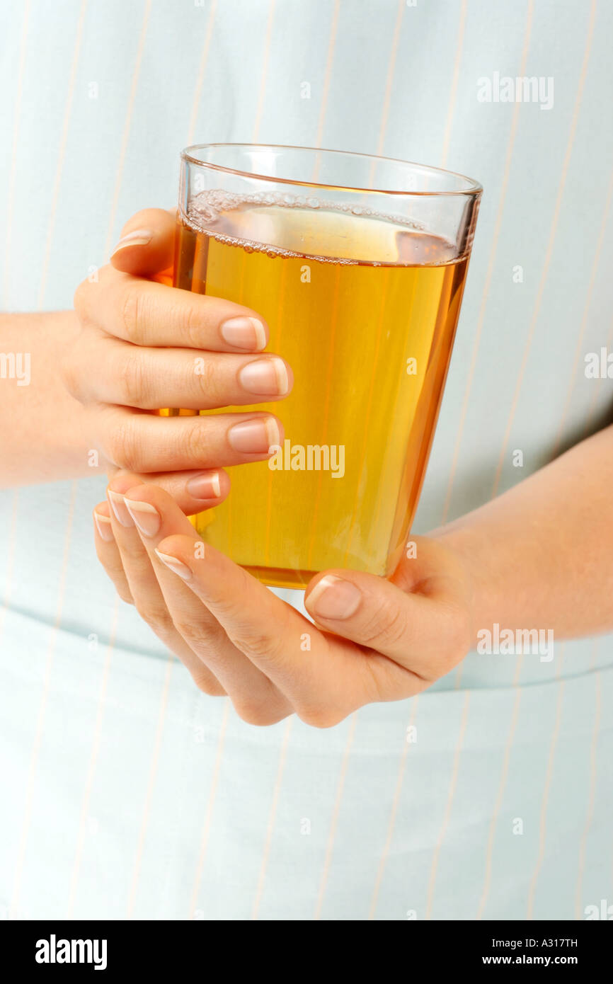 WOMAN HOLDING GLASS OF APPLE JUICE Stock Photo