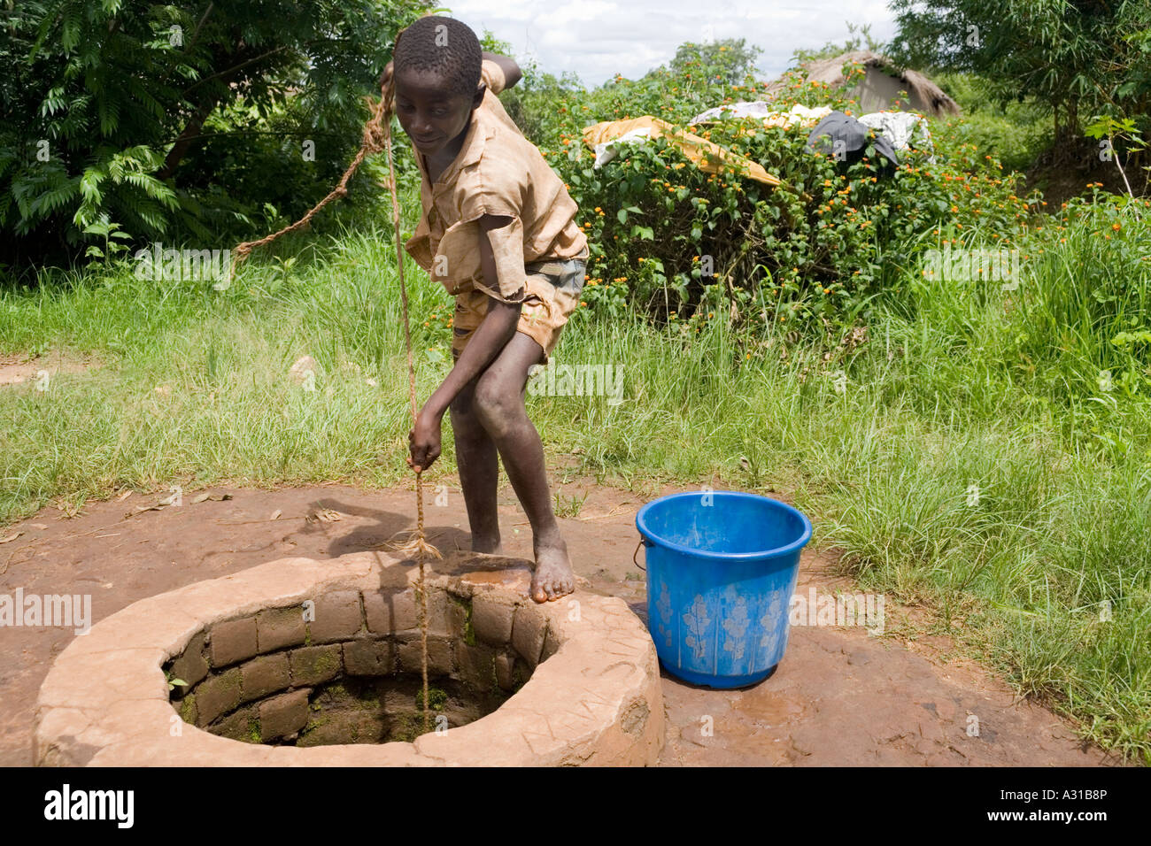 Boy drawing water from a well in the village of Mombala (Mambala Stock