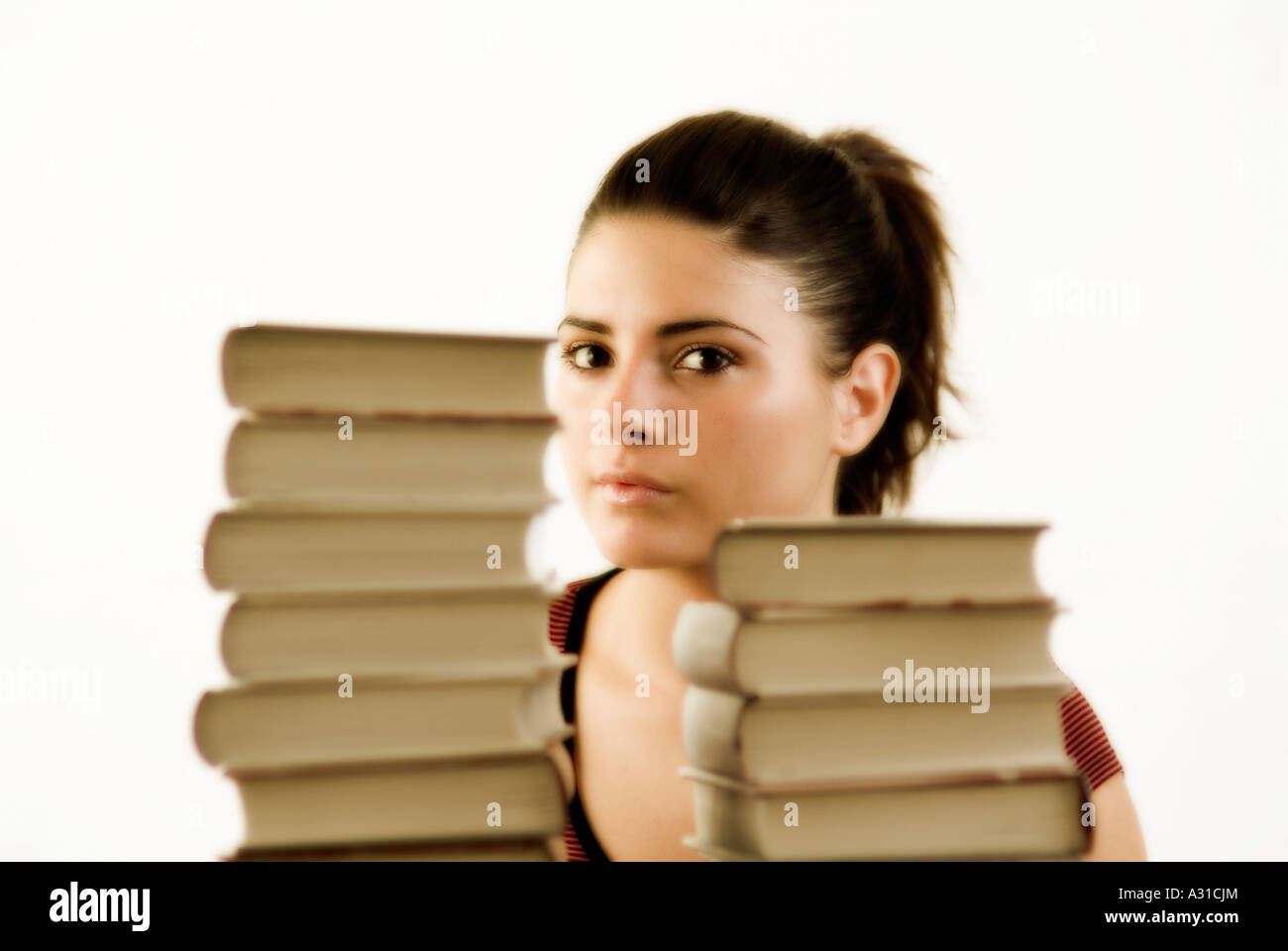 Young girl with piles of books Stock Photo