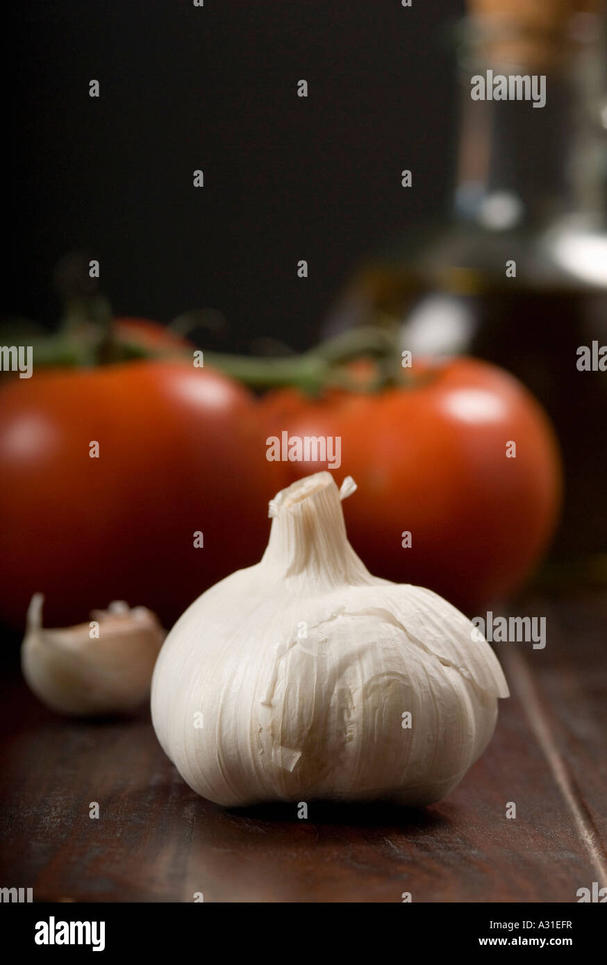 Bulb of garlic and vine tomatoes on wooden table Stock Photo - Alamy