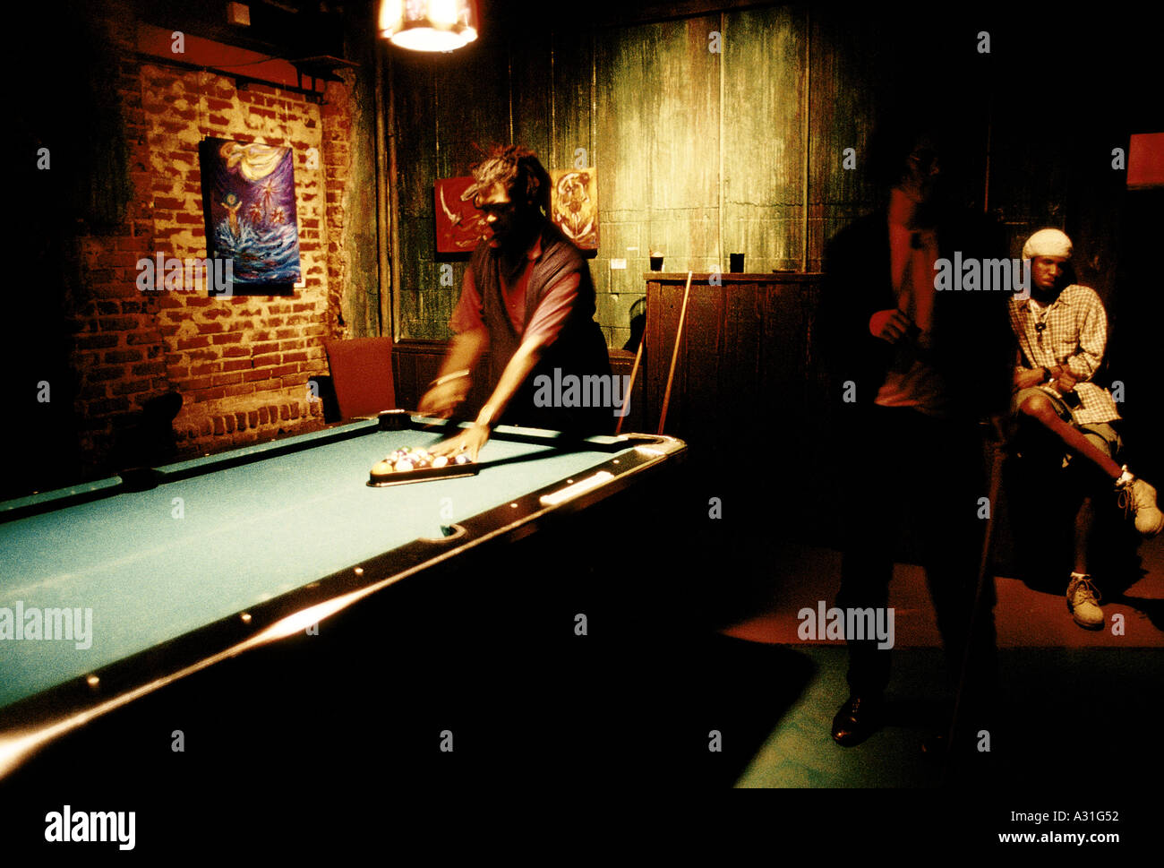 man playing pool setting up balls with triangle on table in an old afro american section of south atlanta georgia Stock Photo