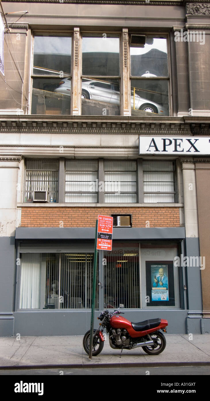 Manhattan street with car on a ramp inside the second floor windows ...