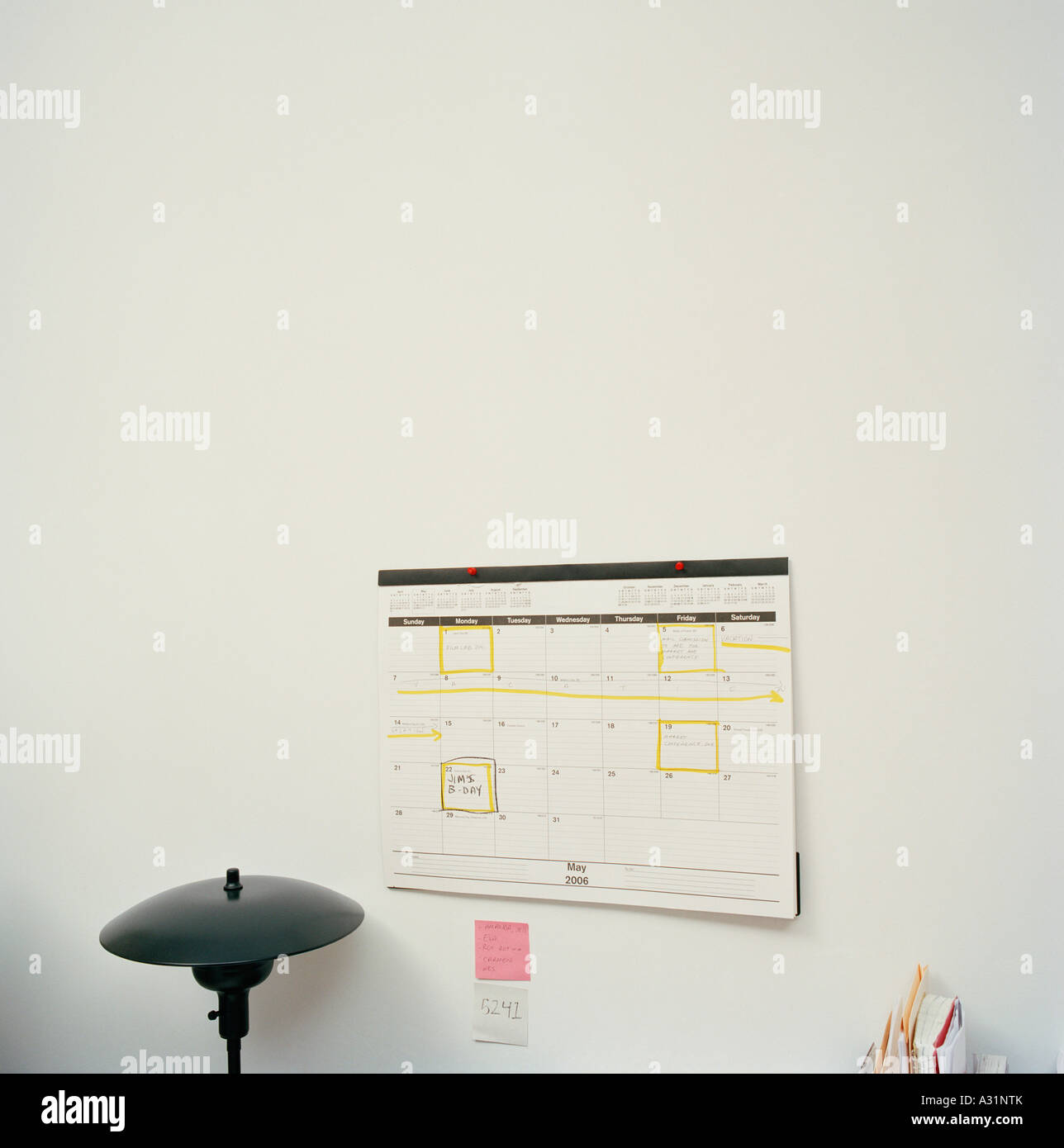 Calendar attached to wall above desktop Stock Photo Alamy