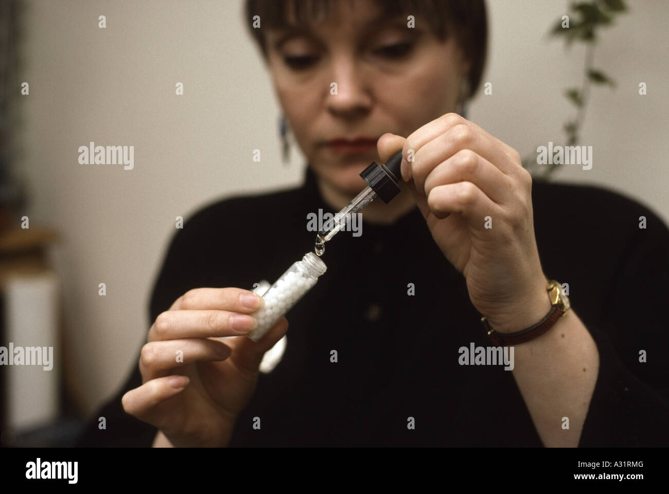 Homeopathic doctor activating pills with homeopathic drops Stock Photo