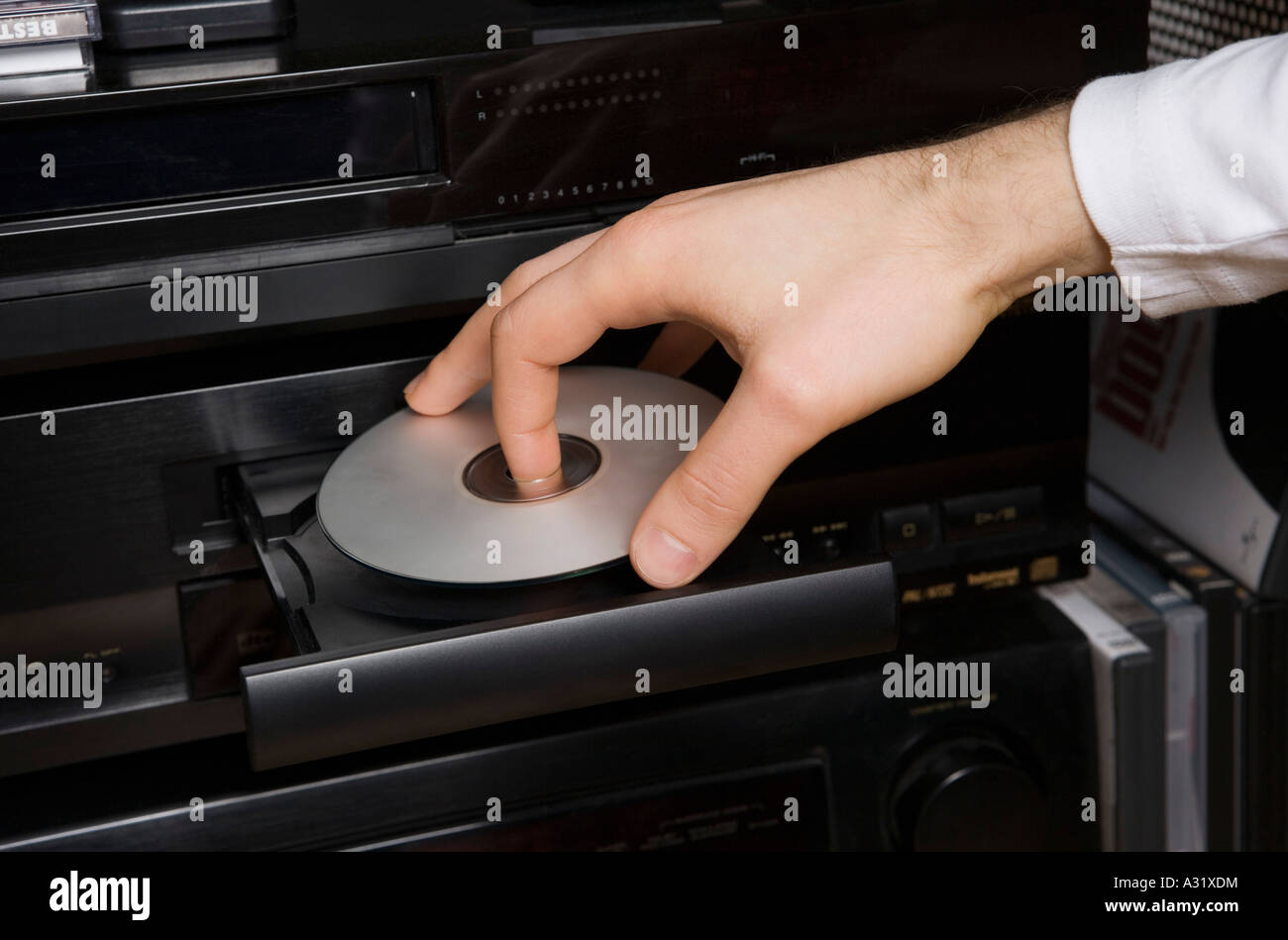 Man inserting disk into DVD player Stock Photo