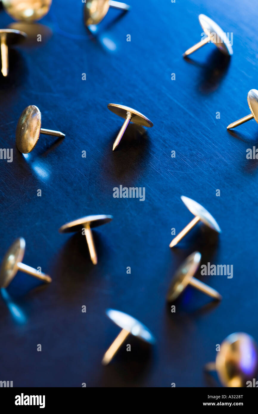 Group of gold thumb tacks on a desk Stock Photo