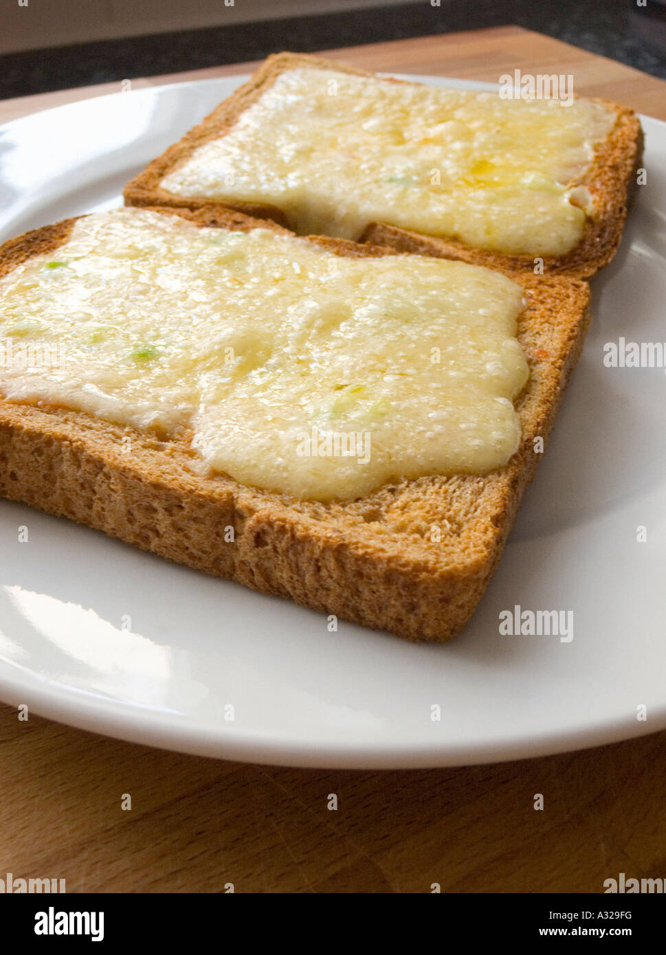 Cheese melt melted on wholemeal brown Toast bread on a plate grill grilled hot Stock Photo