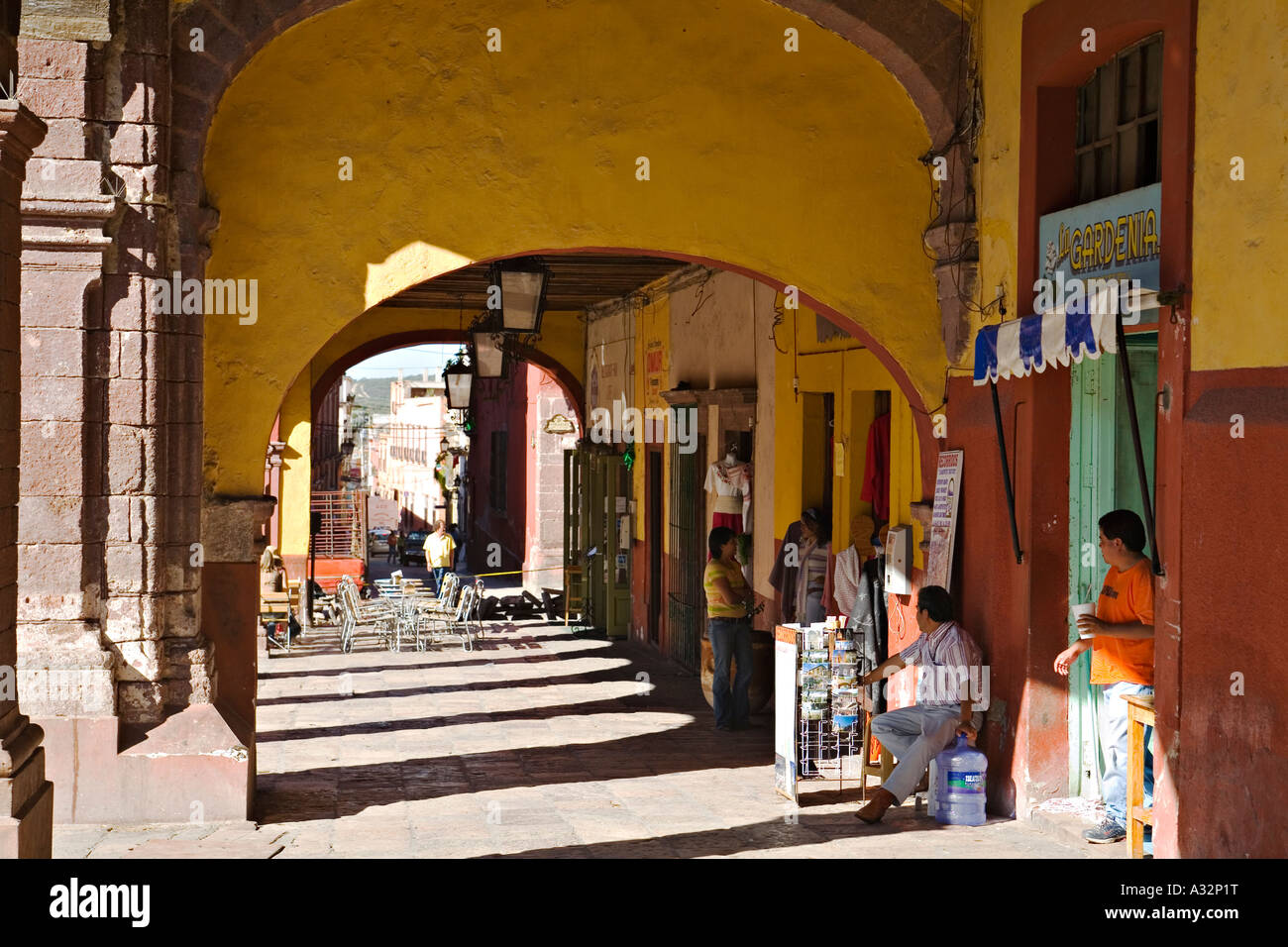 MEXICO San Miguel de Allende People in doorways of stores under arches along el jardin in center of town Stock Photo