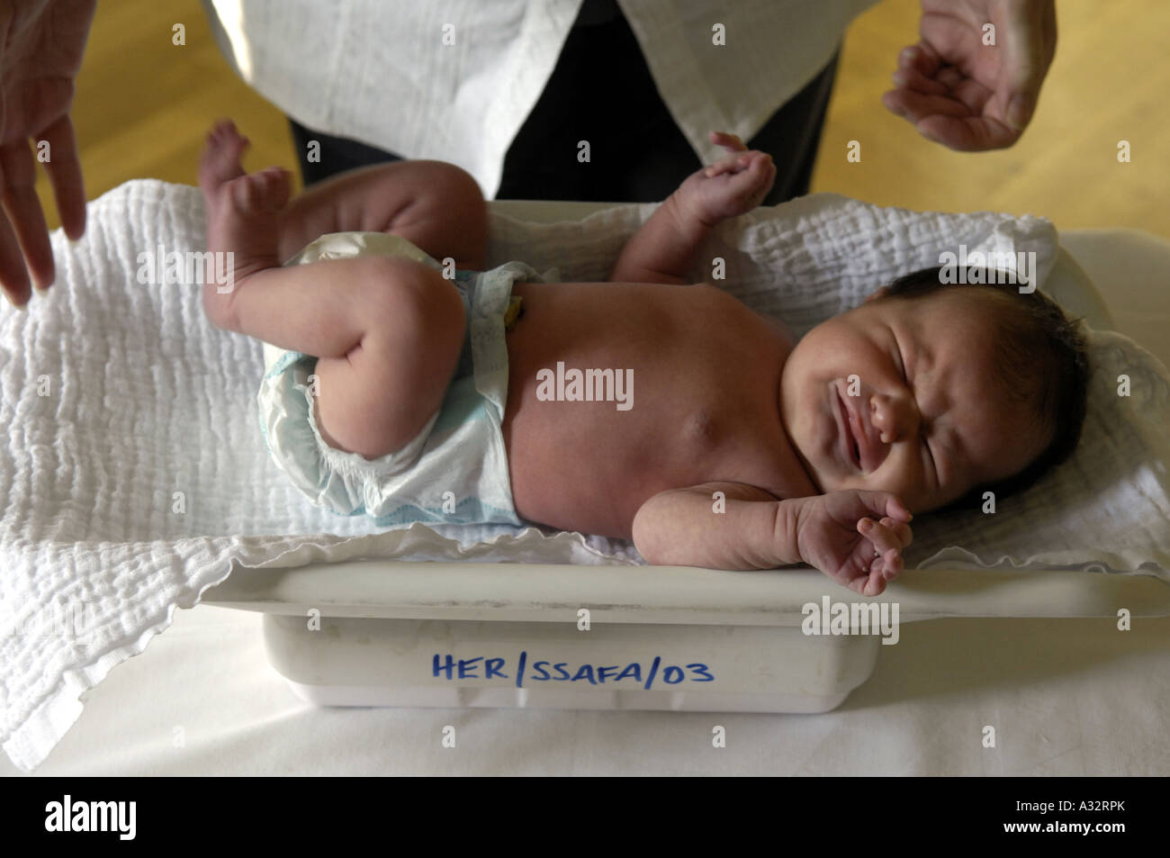 newborn baby face body weigh weight weighing scales health upset cry