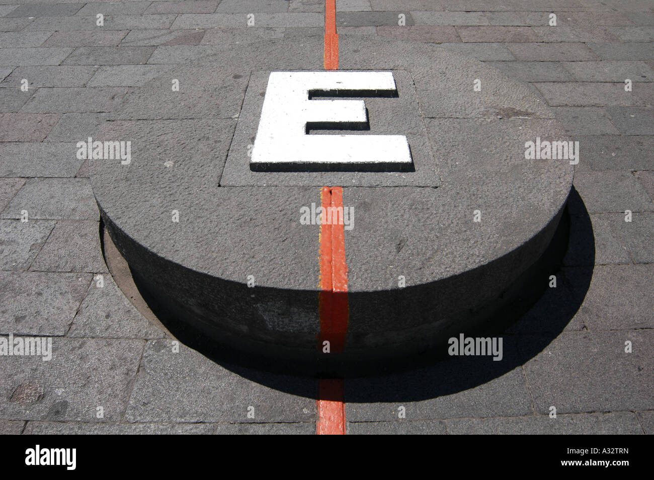 Symbolic Equator line and huge letter 'E' in foot of the Monument Mitad del Mundo (Middle of the World) near Quito, Ecuador Stock Photo