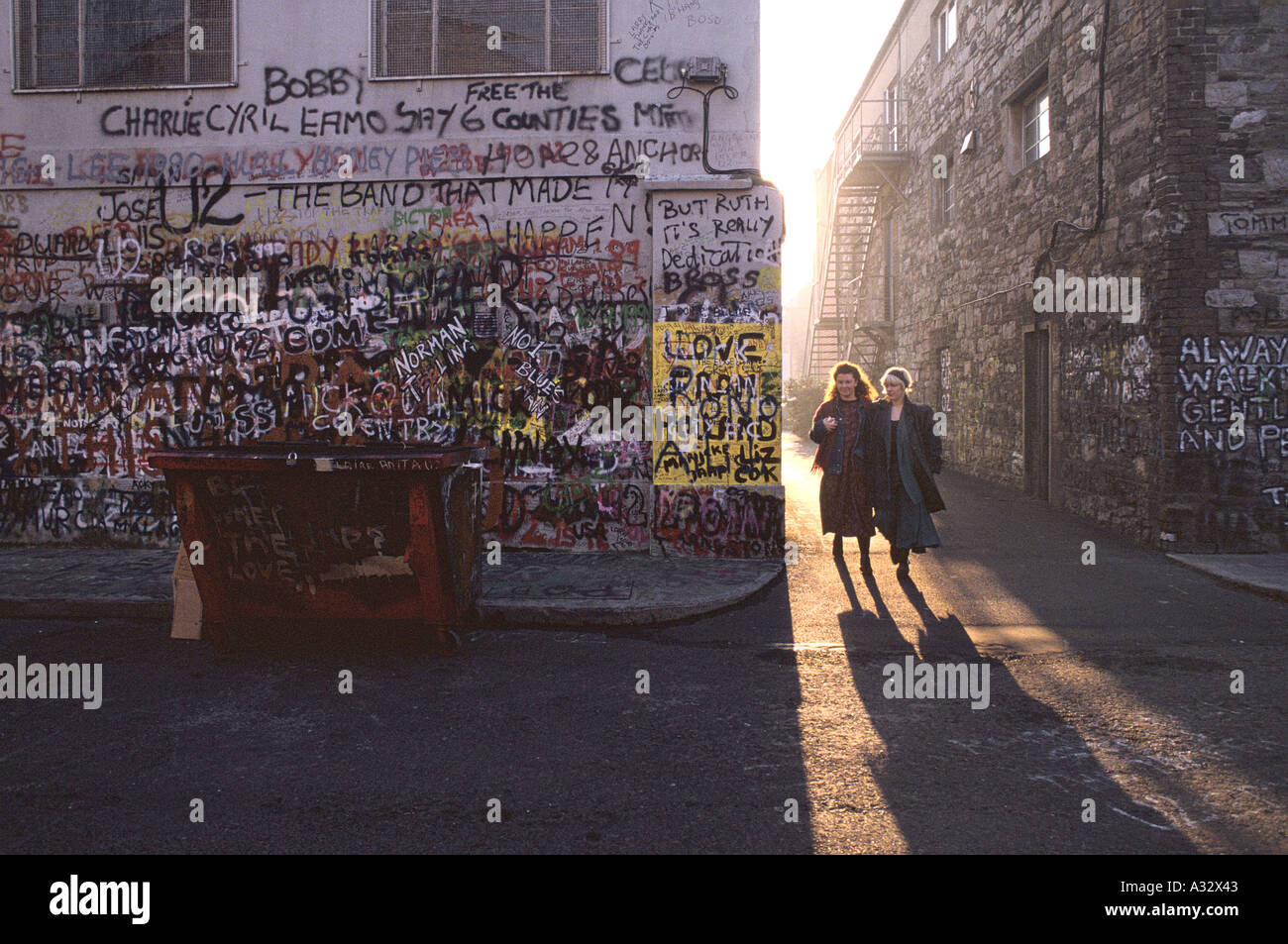 Women walking: graffiti by U2 fans, Windmill Lane, Studios, Dublin. Stock Photo