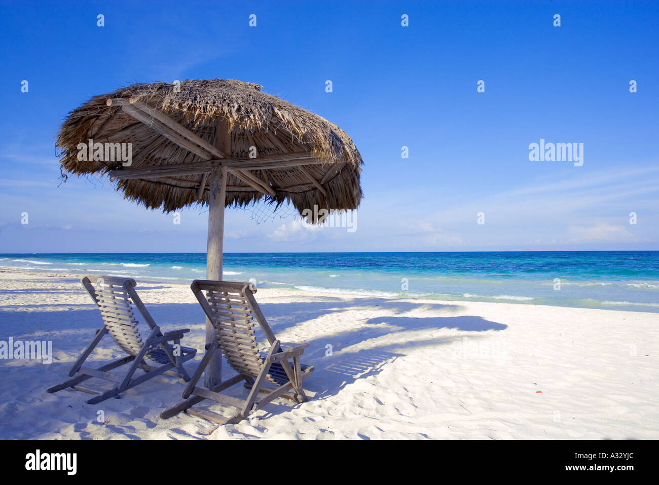 Caribbean beach scene with two chairs under shade palapa near Cancun, Mexico. Stock Photo