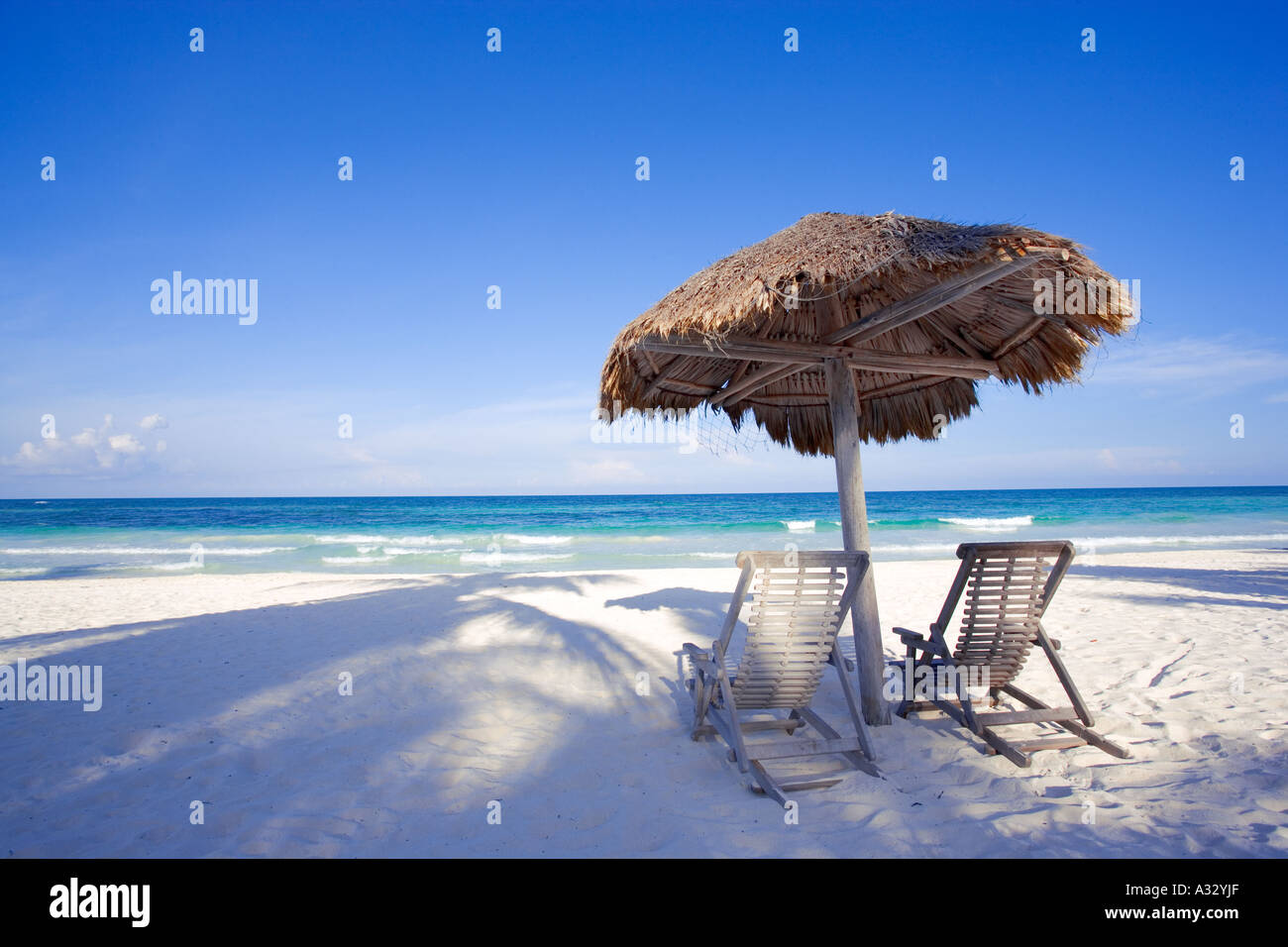 Caribbean beach with two chairs under shade palapa.  Tulum, Mexico, Quintana Roo Stock Photo