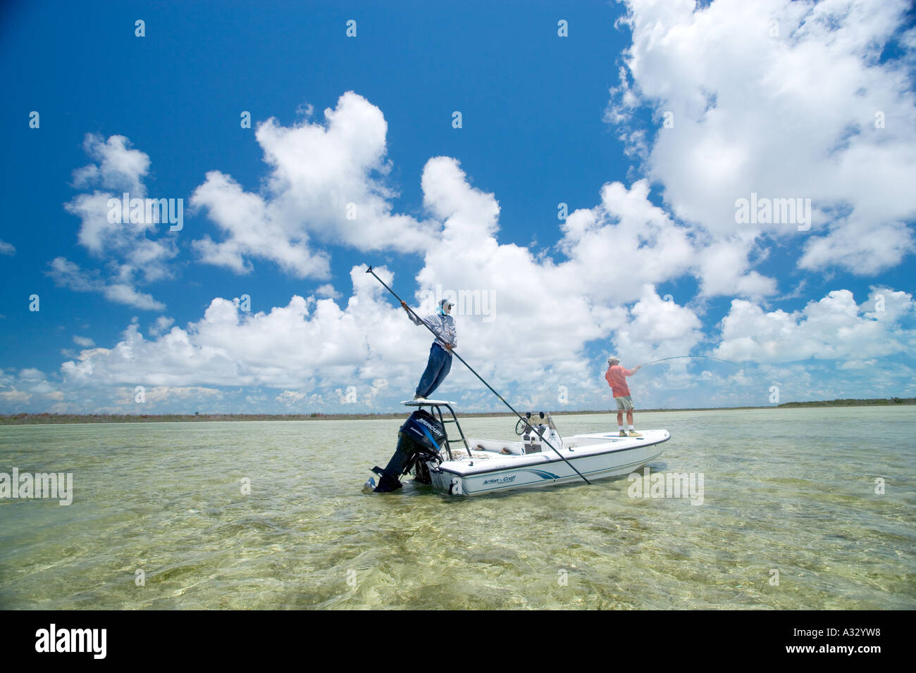 Bahamas, Abaco. Flats boat with fishermen looking for bonefish while fly  fishing Stock Photo - Alamy