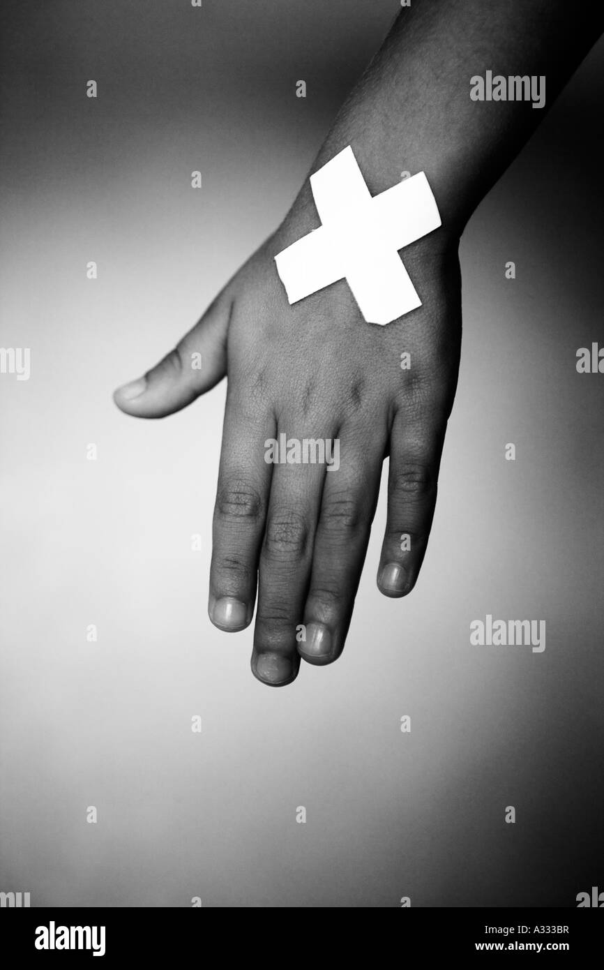 Sticking plasters crossed on a hand Stock Photo