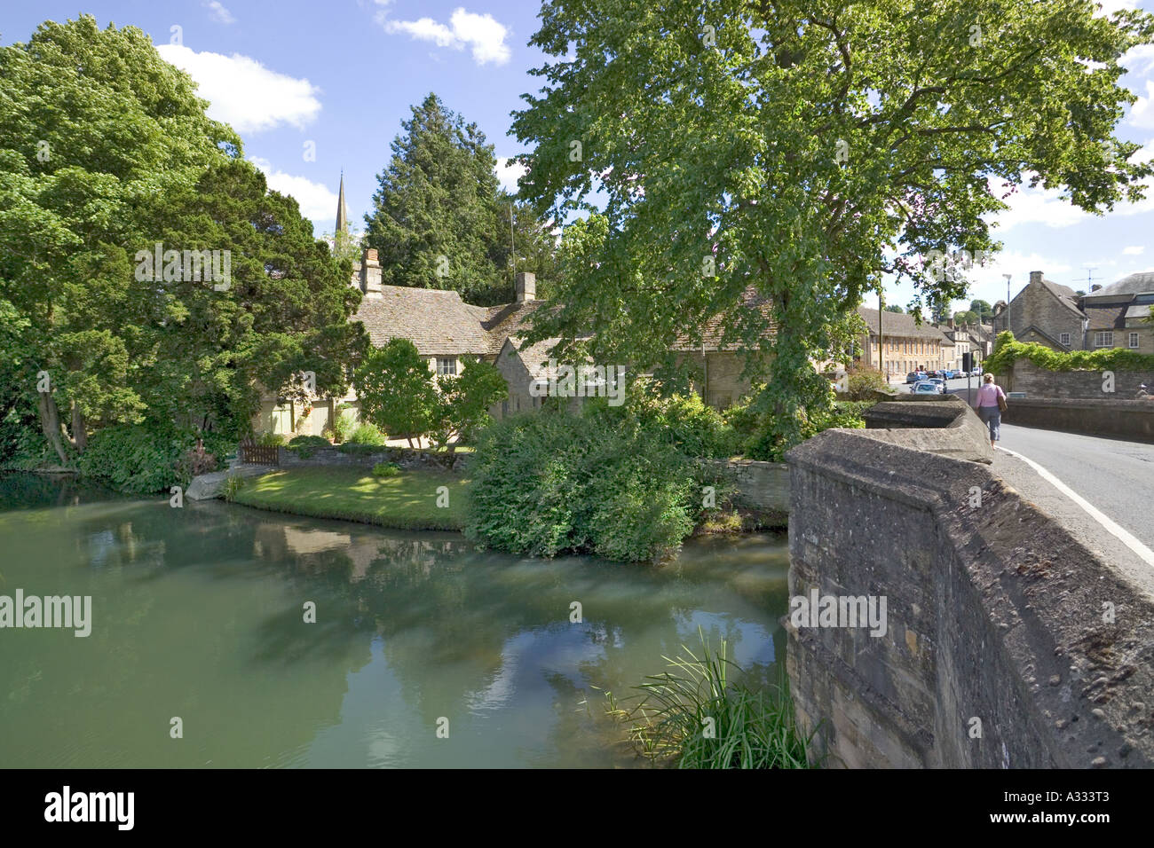 Looking towards the church from the bridge across the River Windrush in the Cotswold town of Burford, Oxfordshire UK Stock Photo
