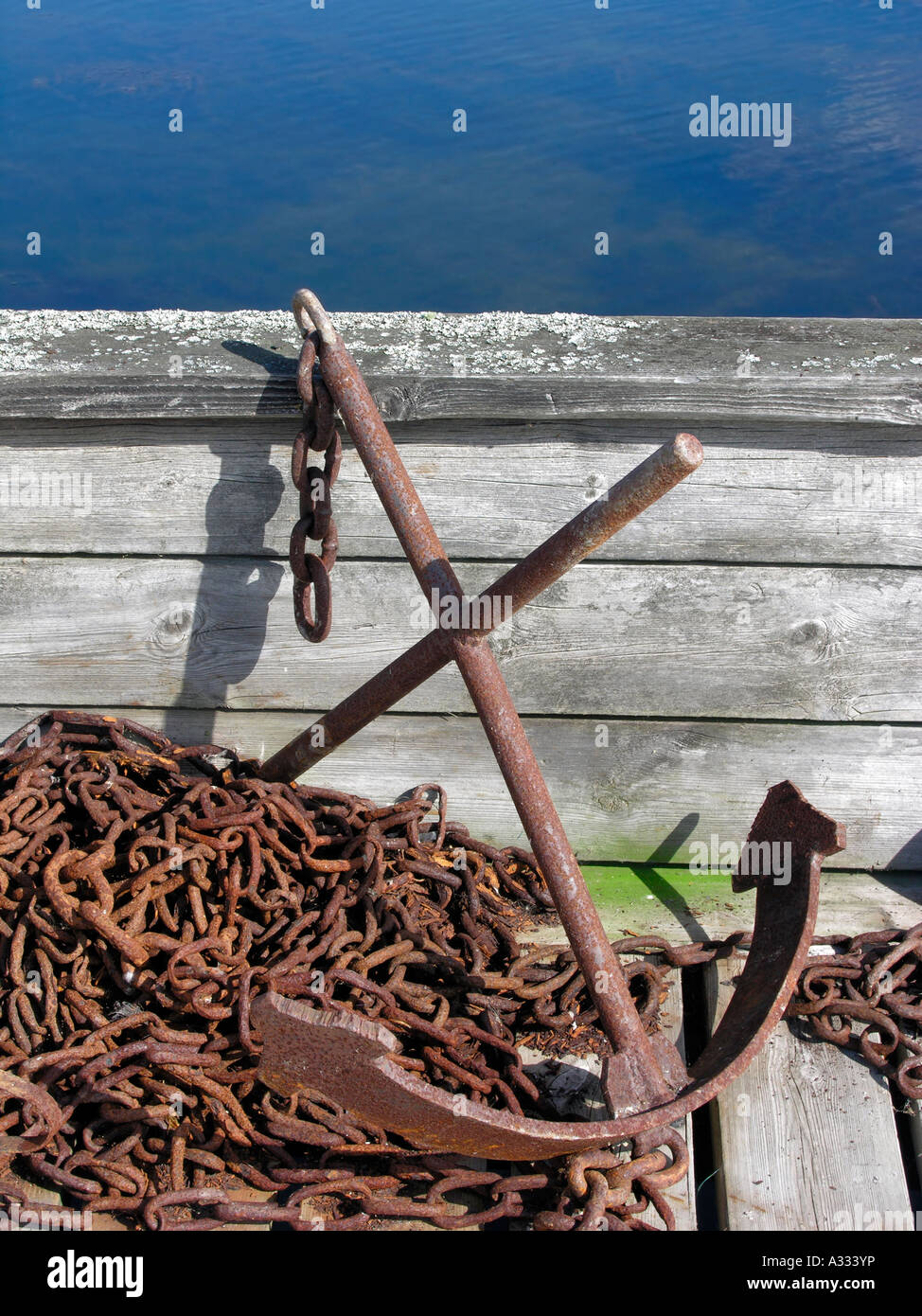 old anchor with rusty chain in an old wooden boat Stock Photo