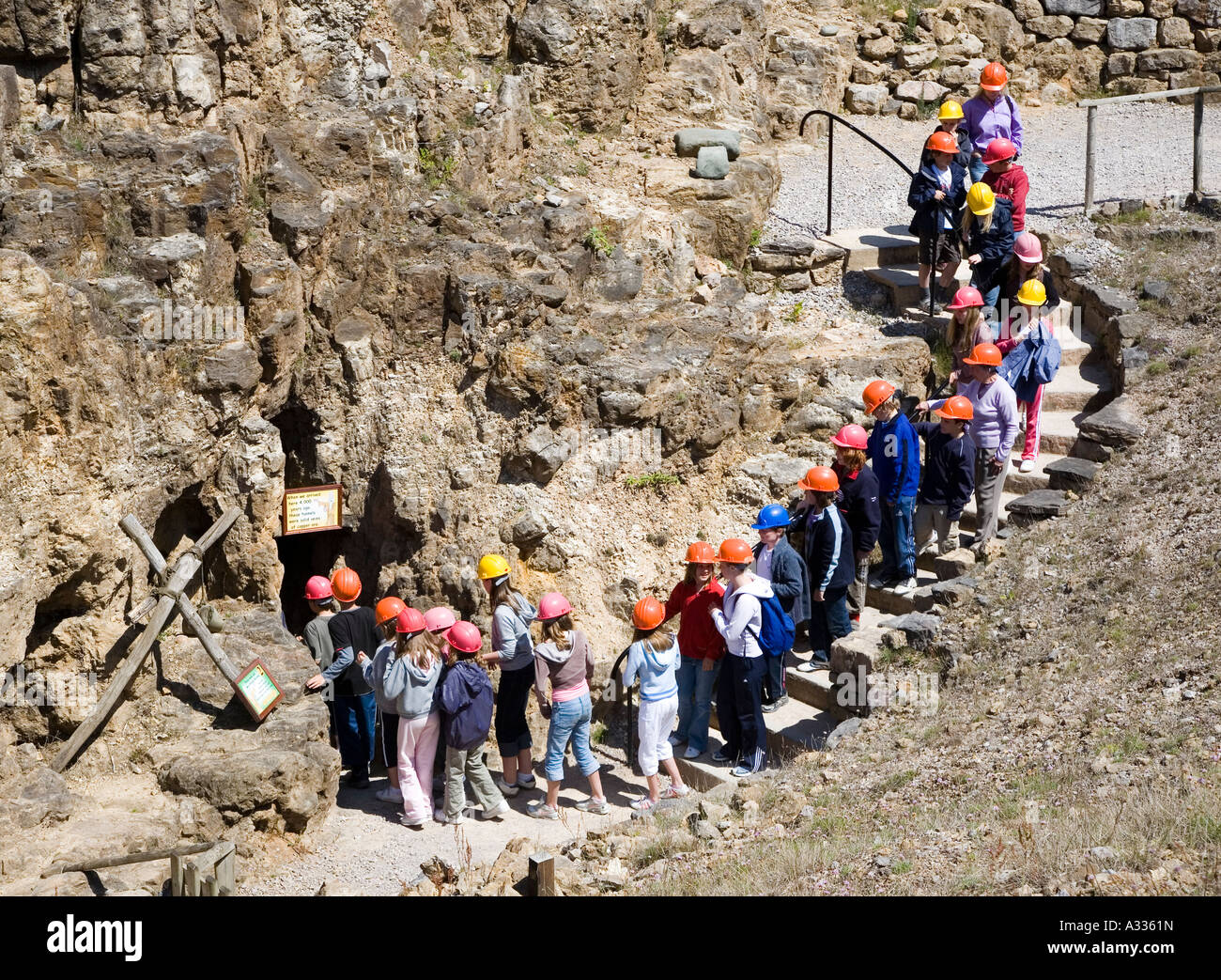 Group of school children entering the underground mine workings at Great Orme ancient copper mines Wales UK Stock Photo