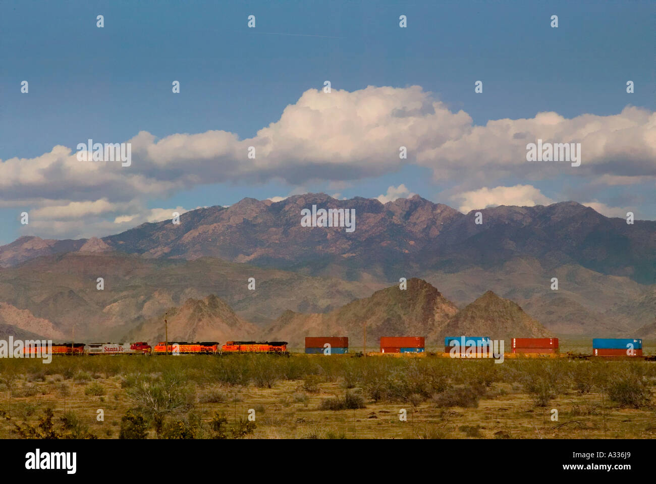 A diesel freight train in the Arizona desert passes the Hulapai Mountains north of the town of Yucca Stock Photo