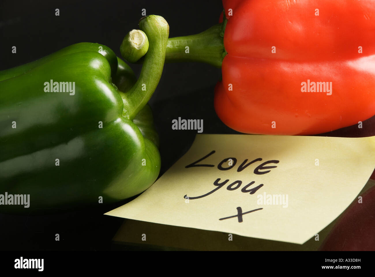 Intertwined peppers with romantic note Stock Photo - Alamy