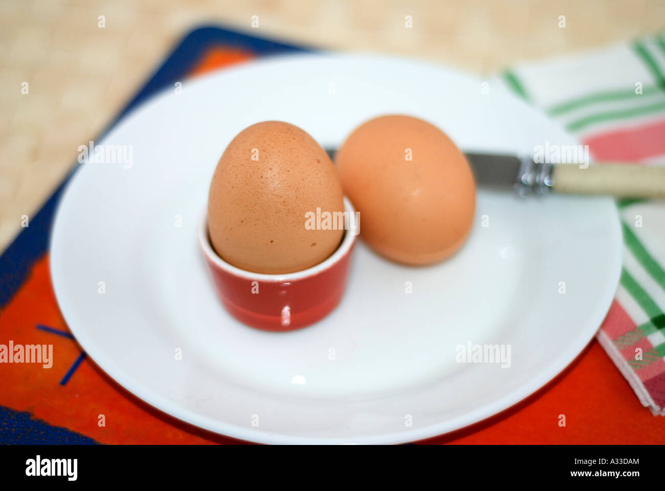 Boiled eggs on plate with knife Stock Photo