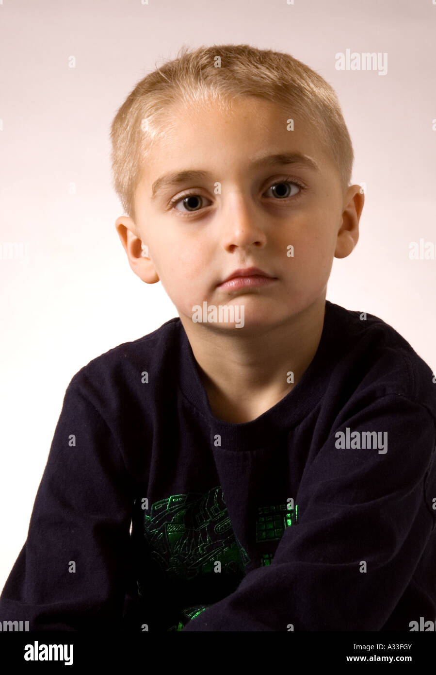 5 year old boy poses for the camera in a formal portrait setting Stock