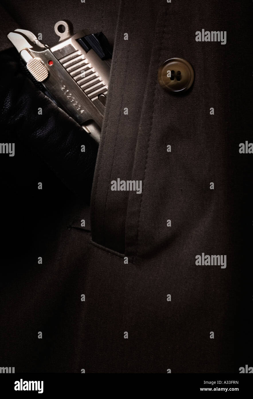 Model pulls semiautomatic pistol from trench coat pocket. Safety is off, pistol ready to fire