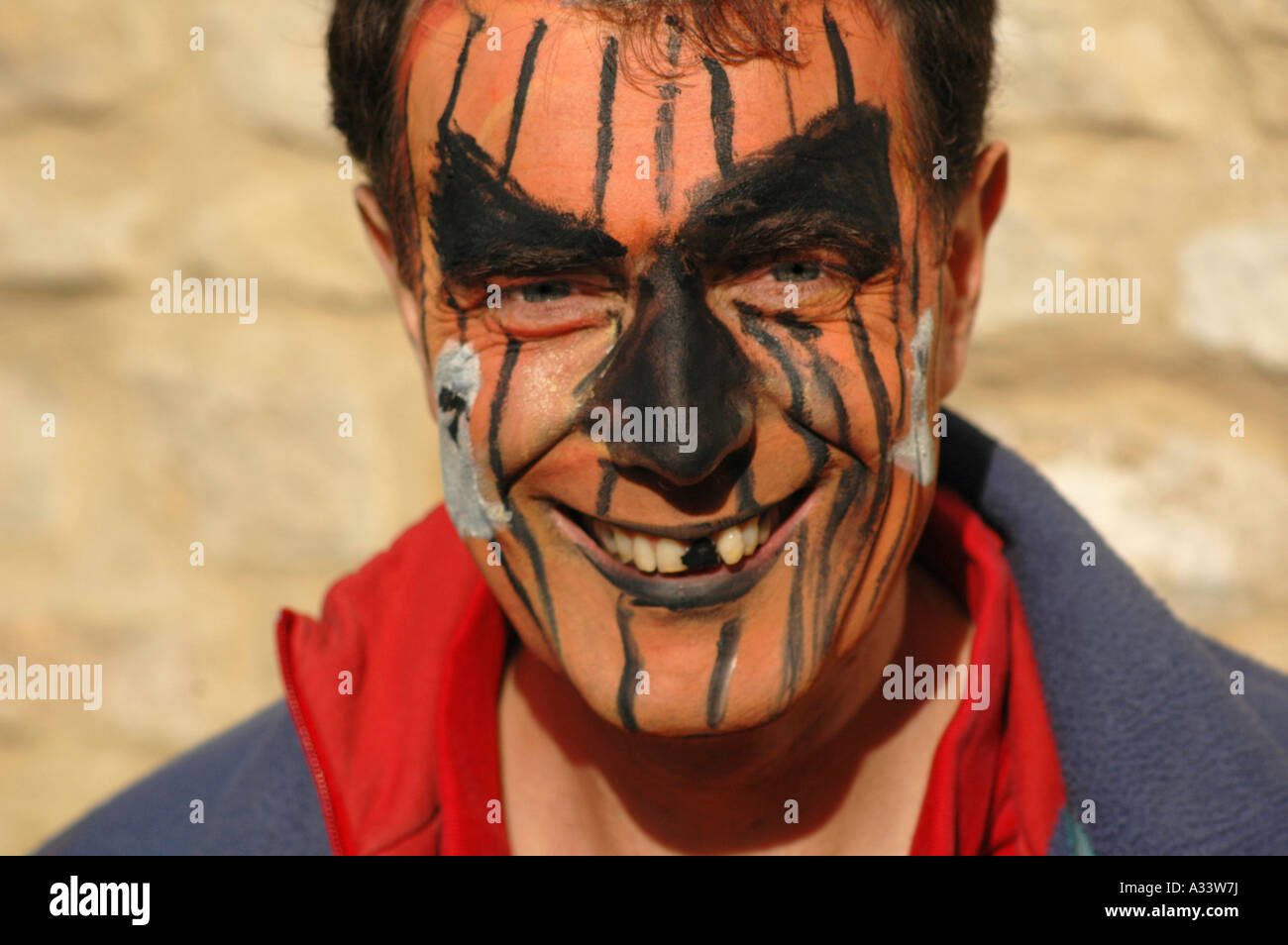 Man with face painted to look like pumkin Stock Photo