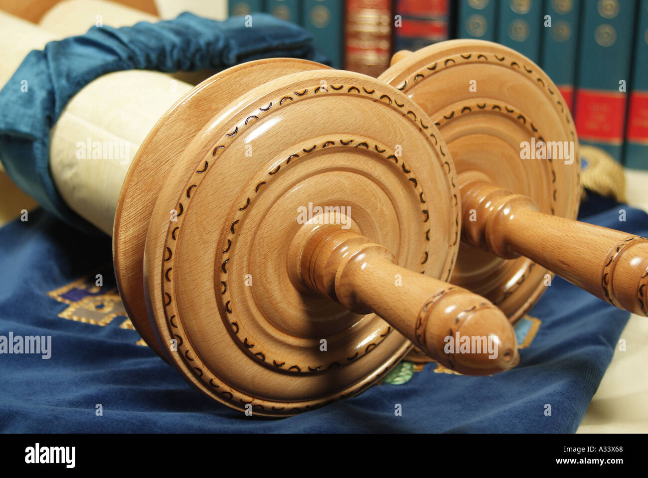 Rolled up Torah scroll with holy books in background Stock Photo