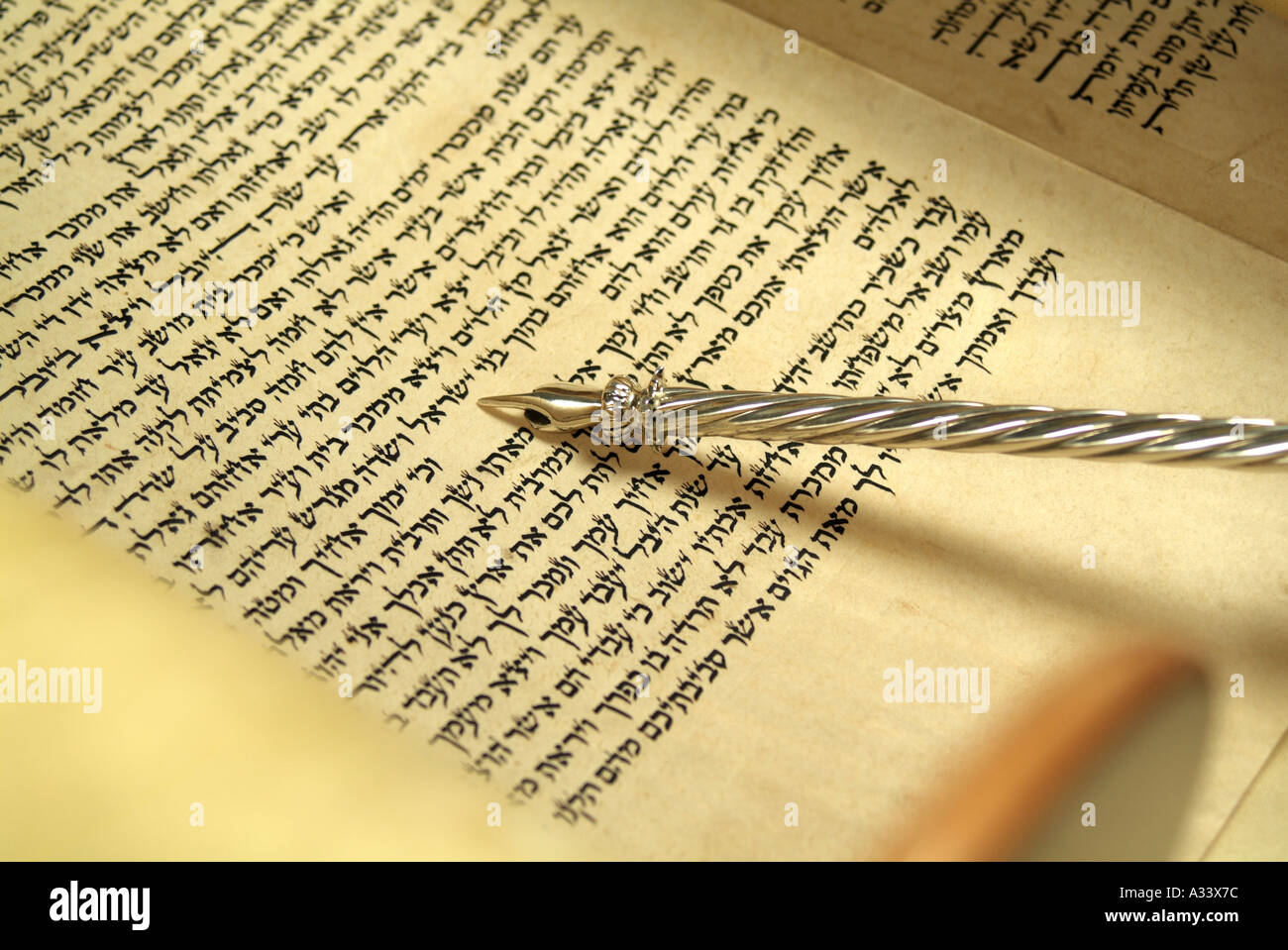 Hebrew Torah scroll with silver yad pointing to Hebrew script Stock Photo