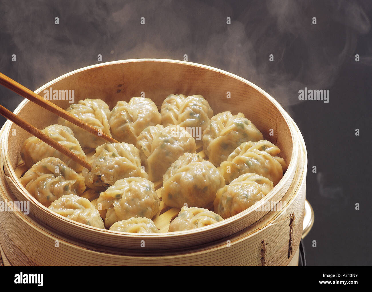 Dim Sum or Chinese dumpling in a stream hot pot of food wheelbarrow on  street food of Bangkok. Many dumpling in a wooden basket is streaming in  old As Stock Photo 