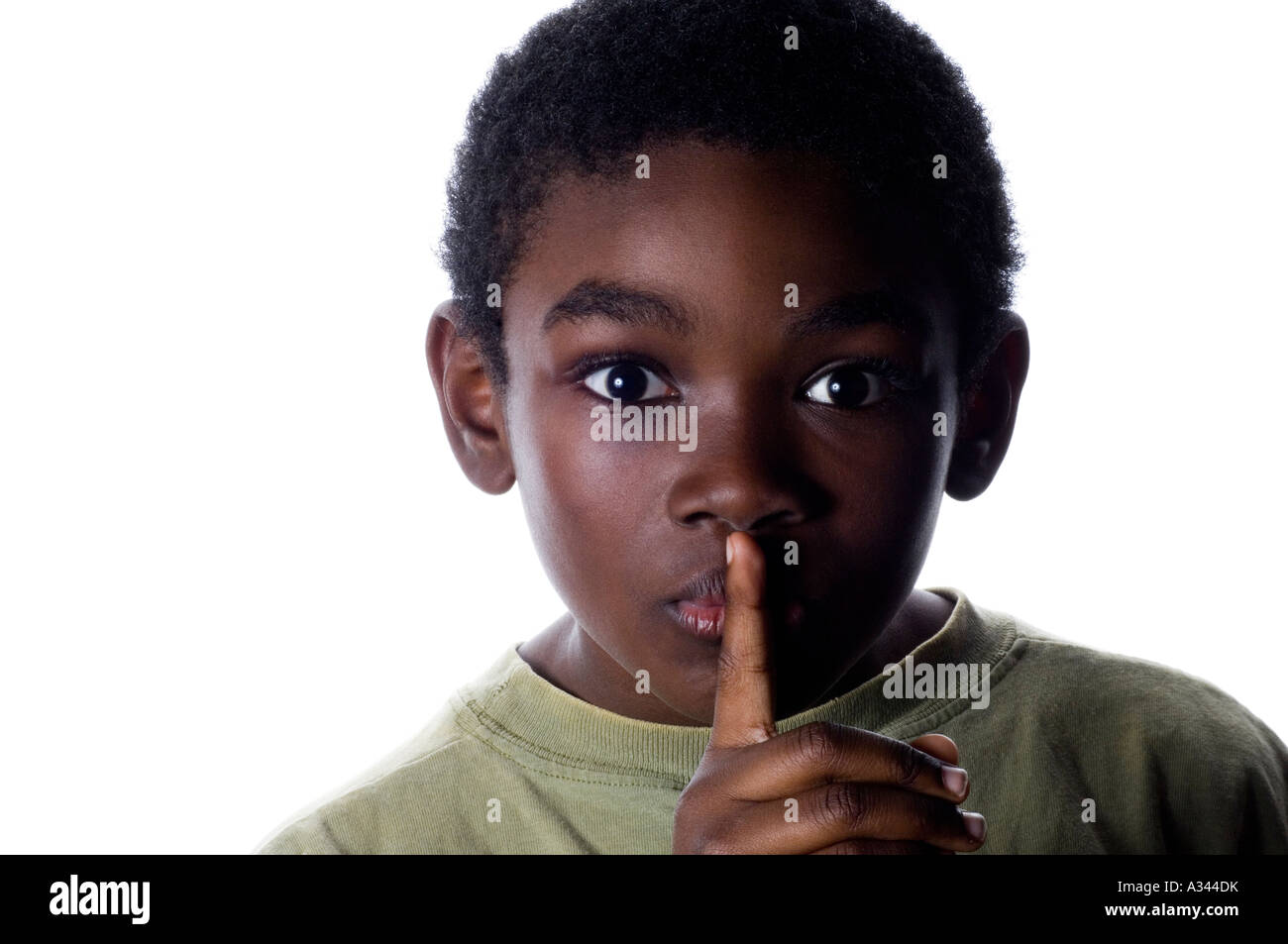 9 years old putting his finger on his mouth on a white background Stock Photo