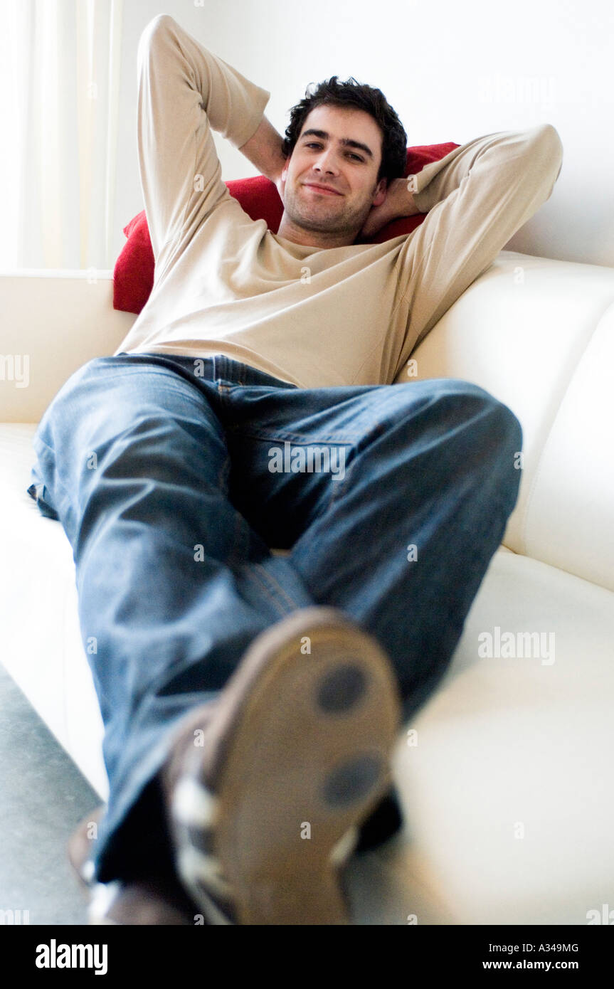 Man resting lying on a sofa Stock Photo - Alamy
