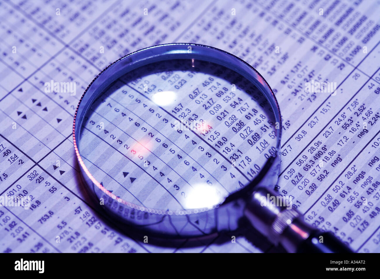 Financial newspaper and magnifying glass Stock Photo