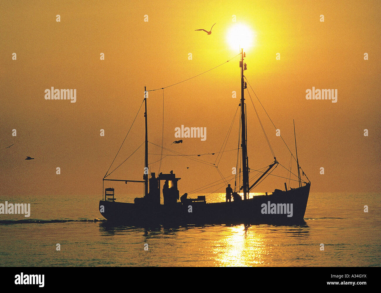 Fishing boat in sunset sea hi-res stock photography and images - Alamy