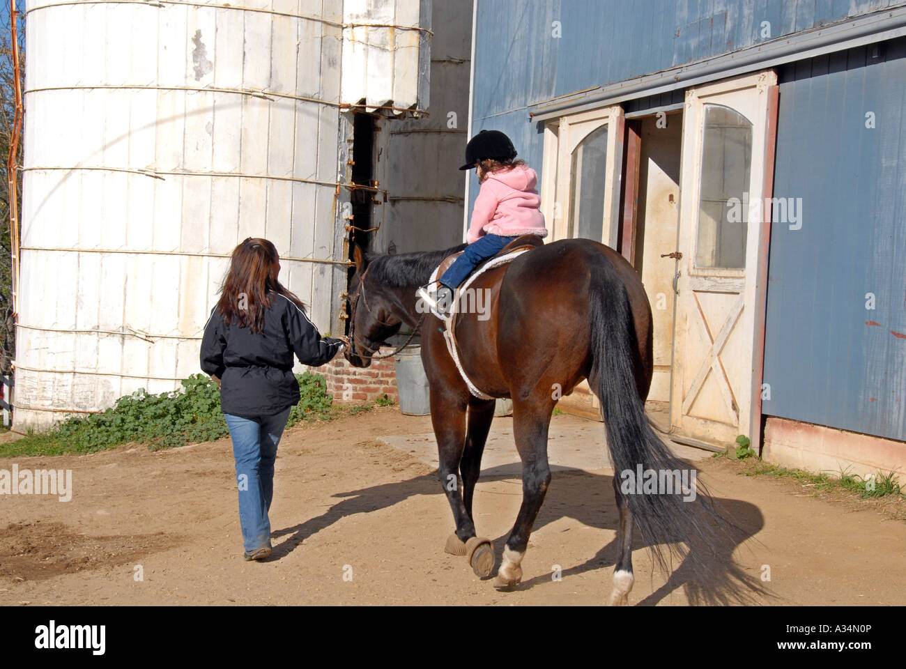 Three year old girl riding a horse mother leading Stanhope Stables