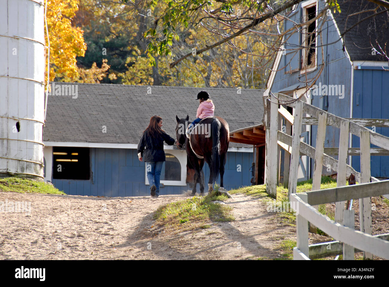 Three year old girl riding a horse being led by her Mother Stanhope