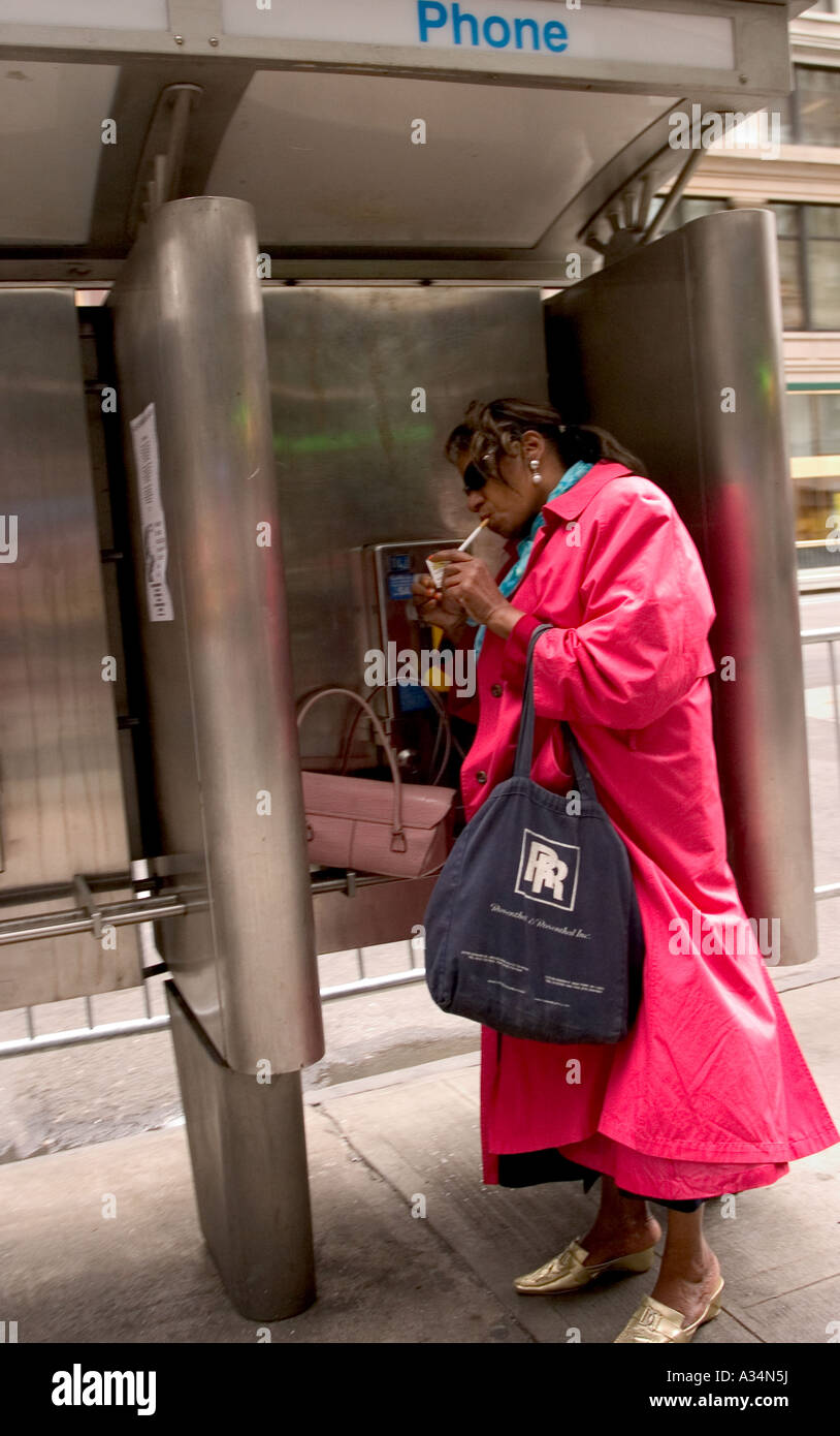 woman smoking in  public phone in manhattan in new york usa Stock Photo