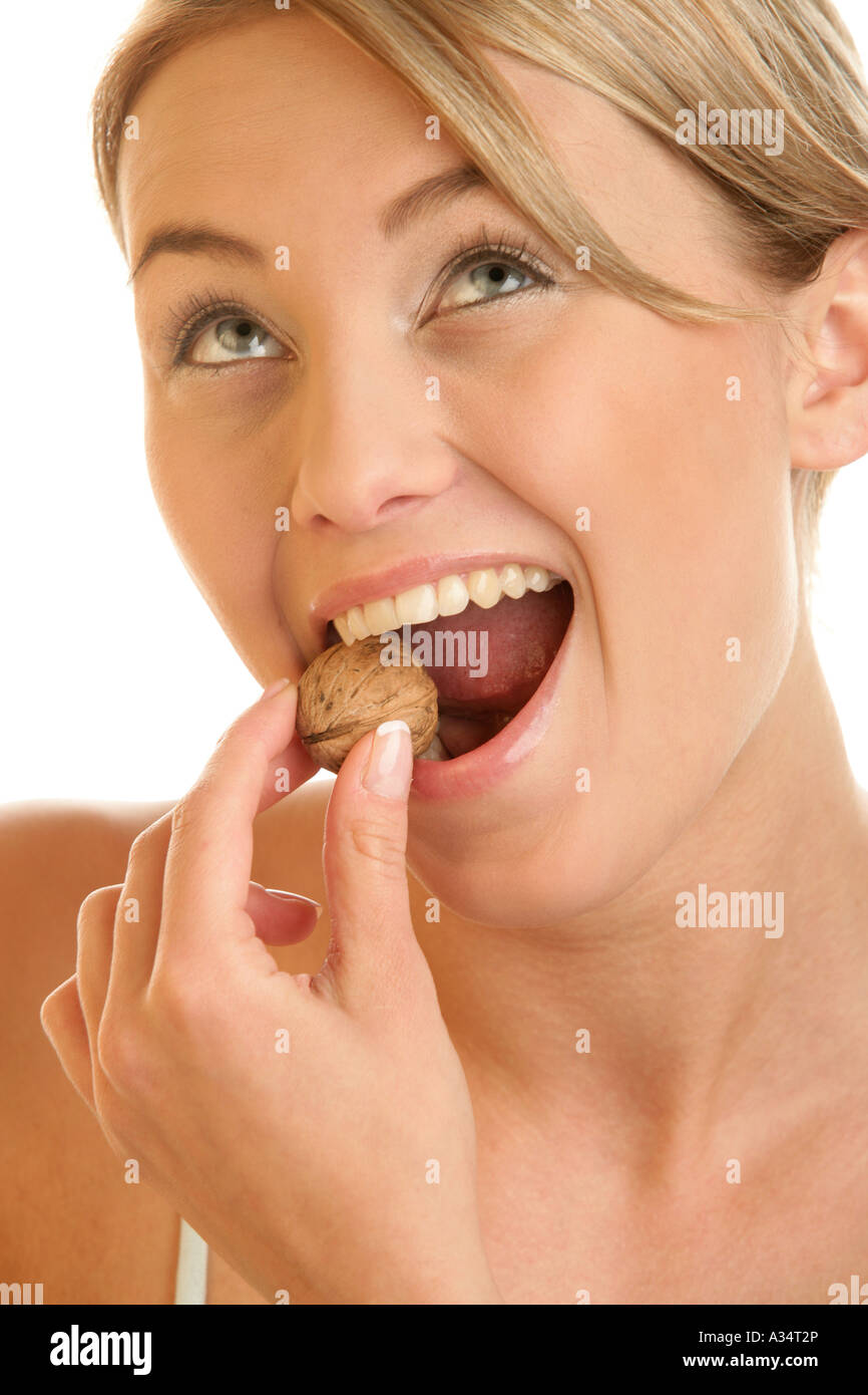Young woman with walnut in her mouth Stock Photo