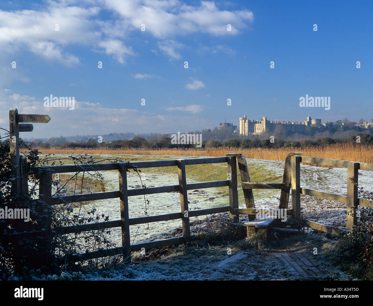 Footpath and stile in a frosty landscape in Arun valley with Castle beyond in winter. Arundel West Sussex England UK Britain Stock Photo